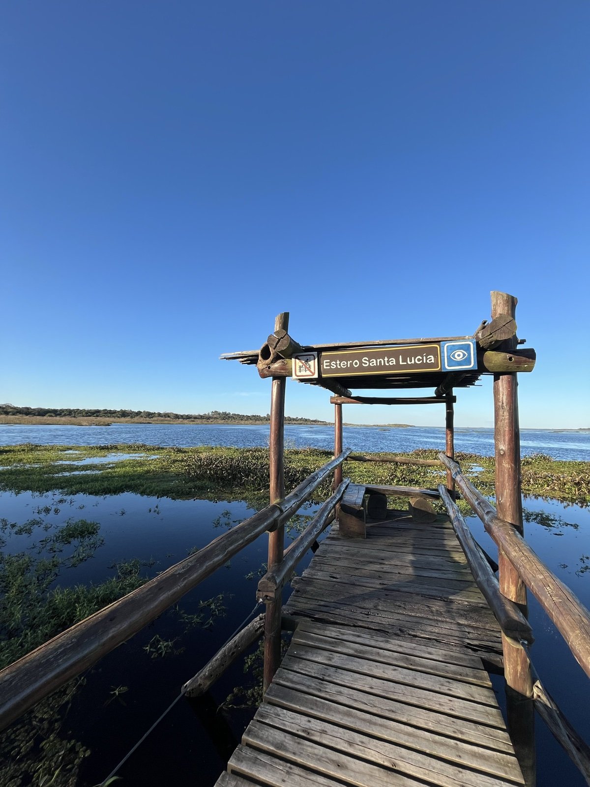 Pasarela de madera con el cartel Estero Santa Lucía en el Parque Nacional Mburucuyá