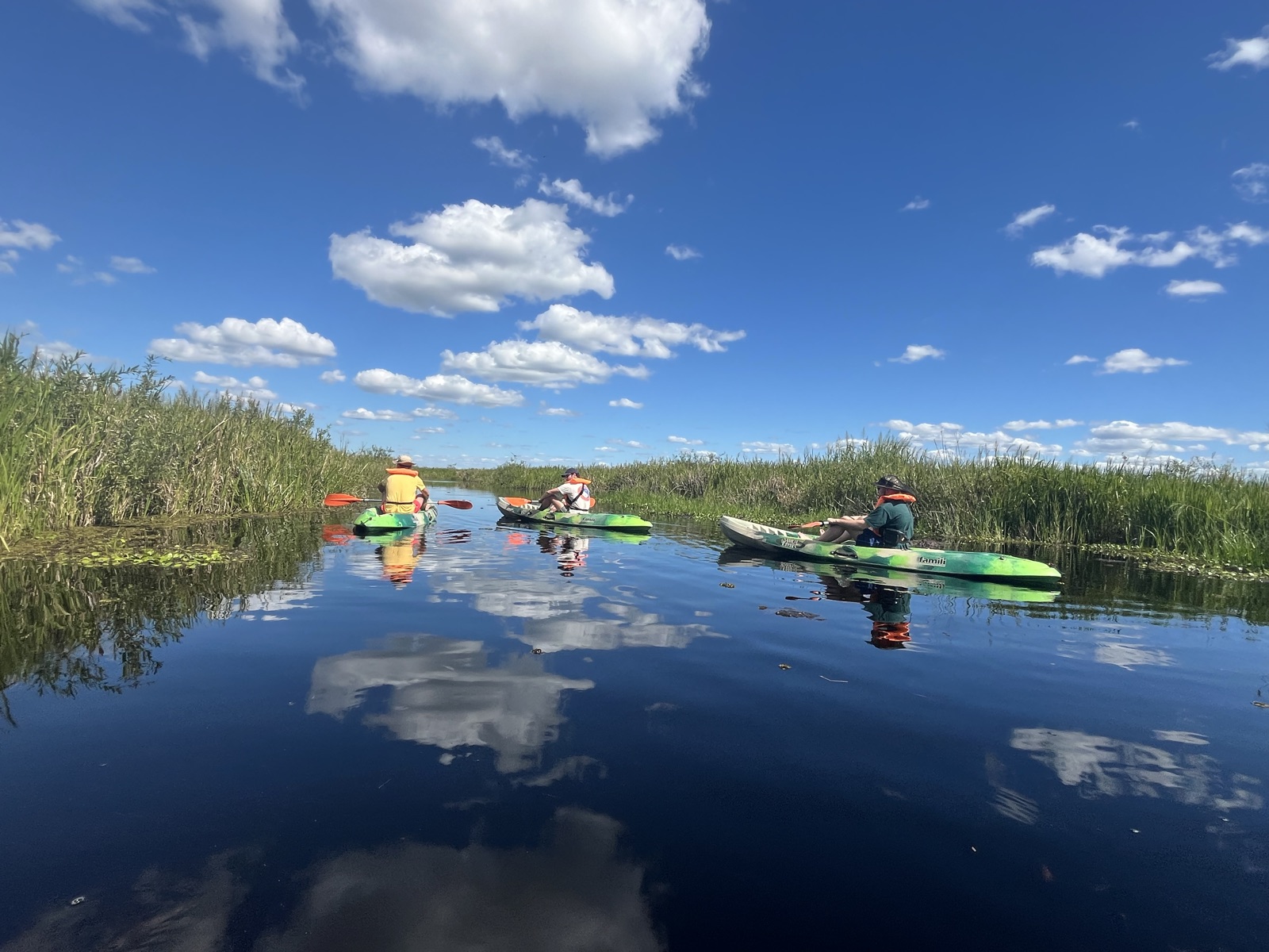 Grupo de kayakistas en los canales del Portal San Antonio con el cielo reflejado en el agua, Loreto