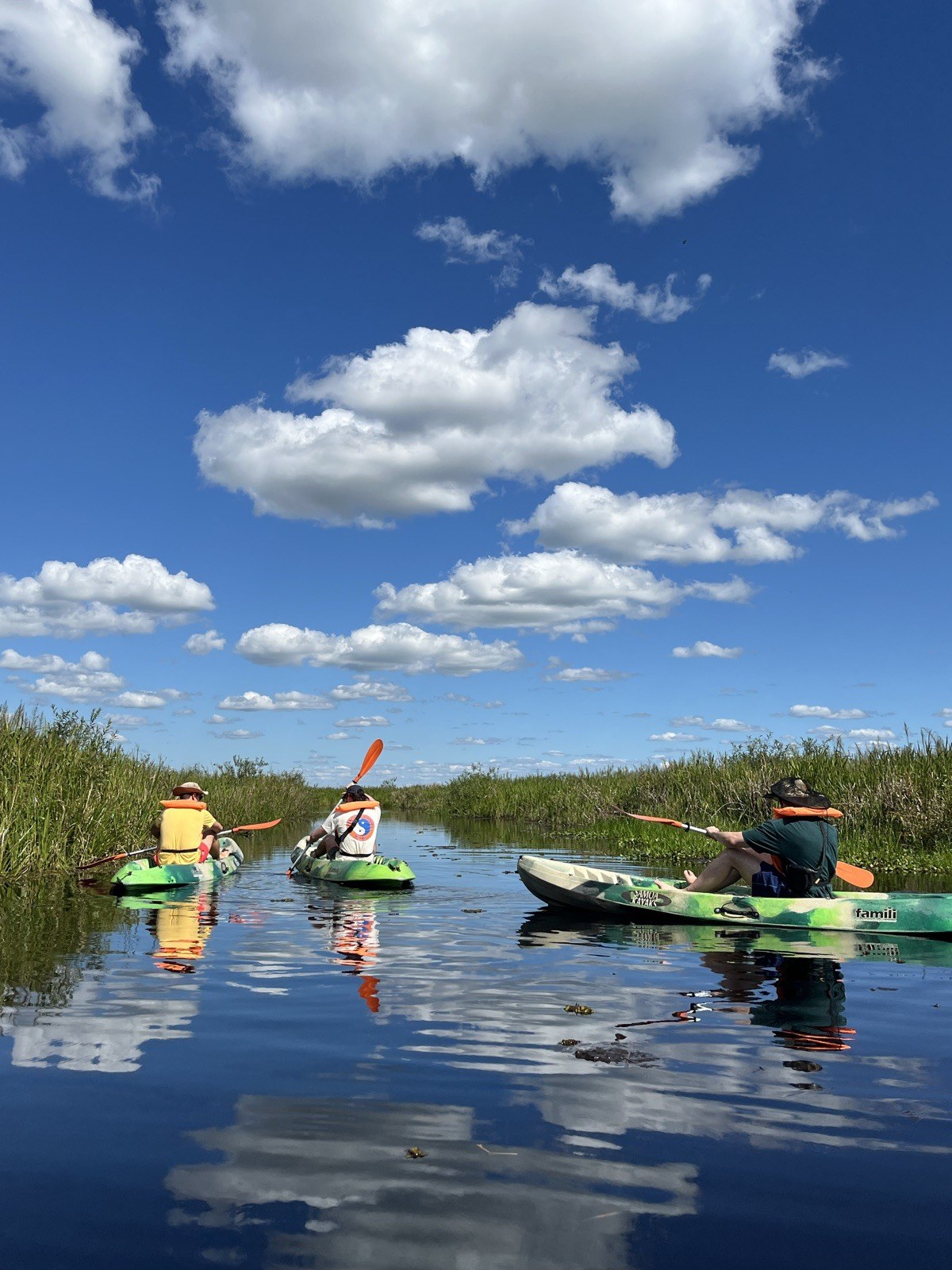 Kayakistas remando por un canal angosto entre pastizales en el Portal San Antonio, Loreto