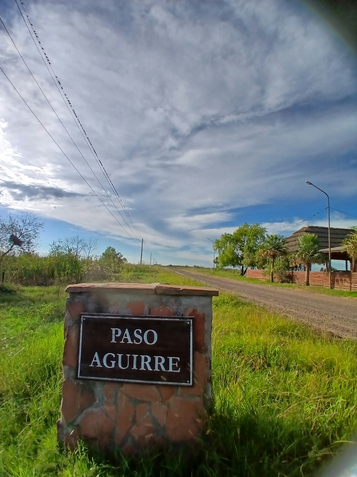 El cartel de Paso Aguirre, al costado del camino de tierra