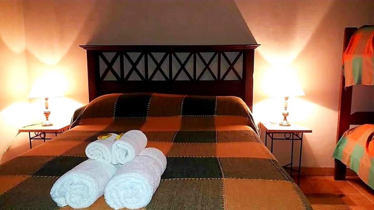 Habitación con cabecera tallada y mantas regionales