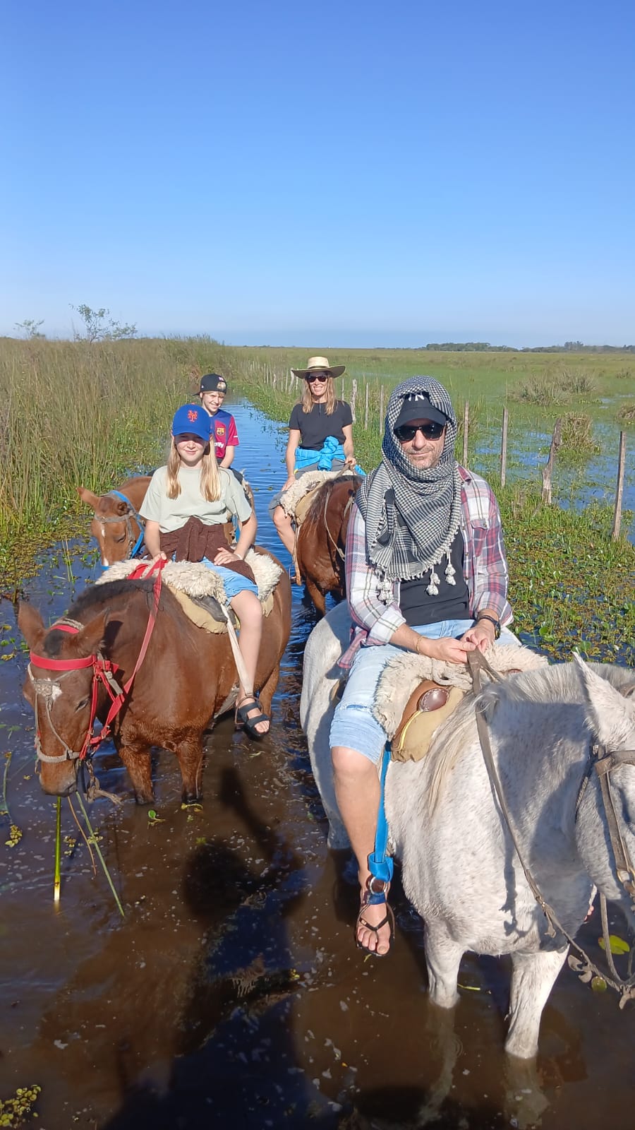 Familia cruzando el estero inundado a plena luz del día con Don Tacho