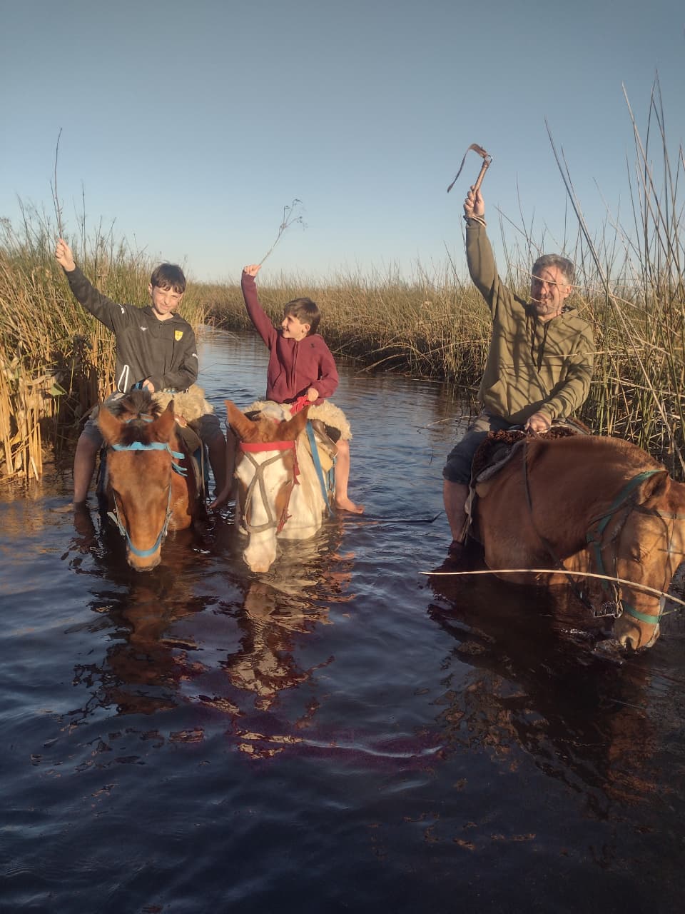 Cruzando el agua al atardecer, con los brazos en alto