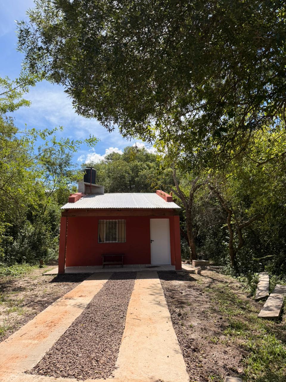 Segunda cabaña, de color ladrillo, con galería y entrada de piedra