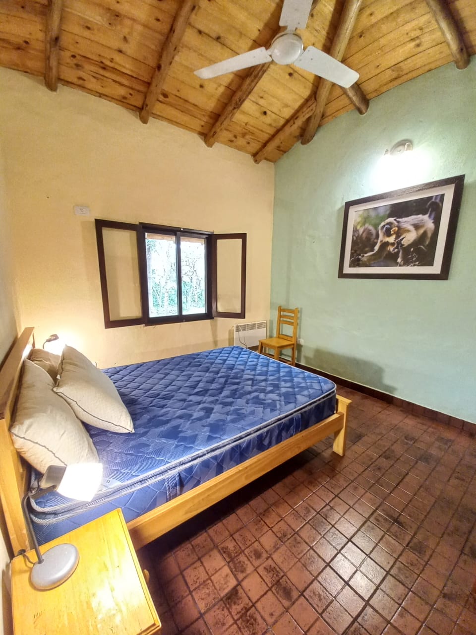 Dormitorio con cama matrimonial y ventilador de techo