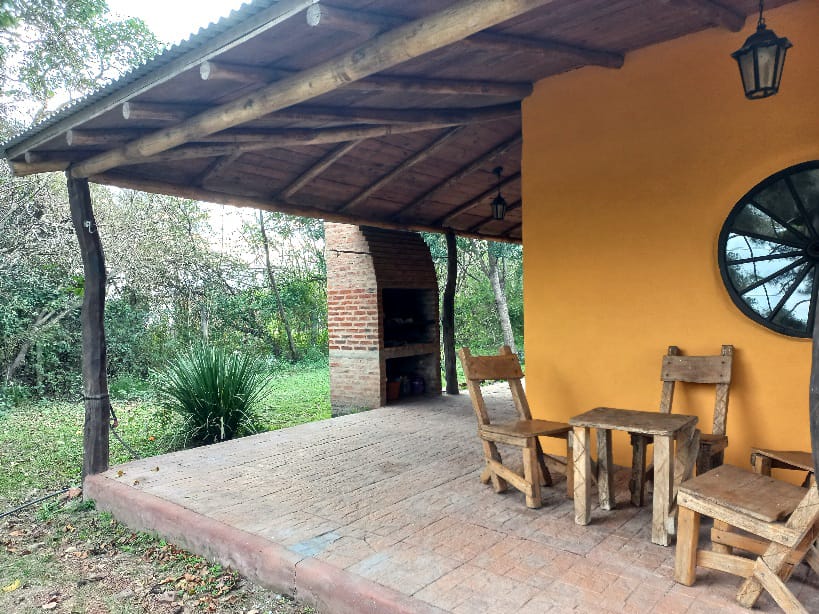 Galería con parrilla y mesa rústica