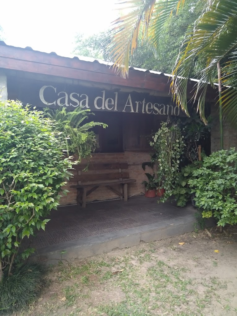 Entrada de la Casa del Artesano rodeada de vegetación en Carlos Pellegrini