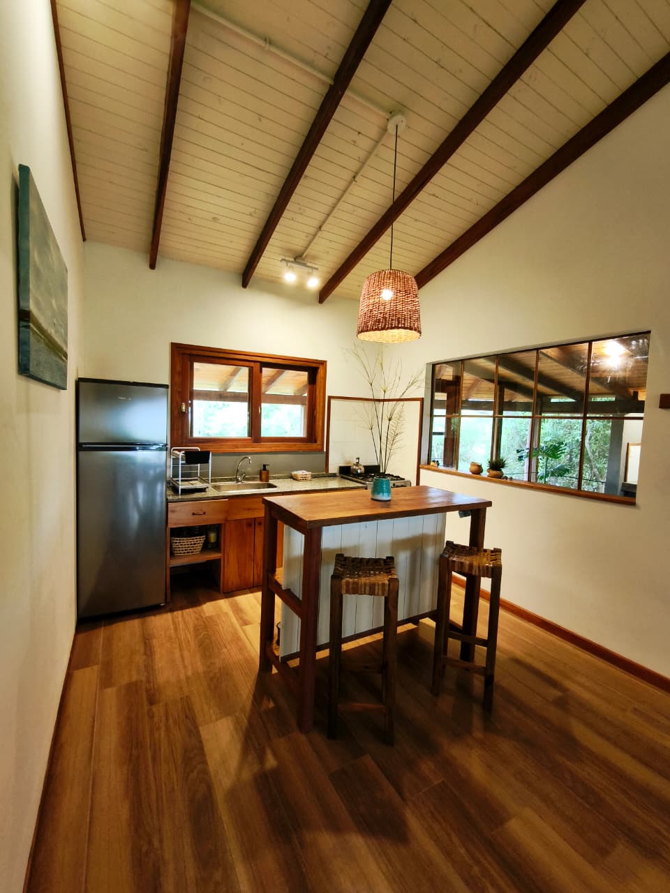 Cocina equipada con isla de madera y ventanas al jardín