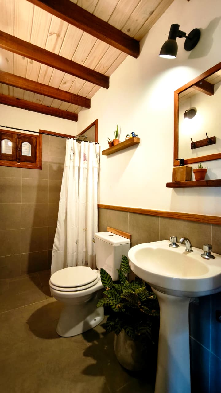 Baño con vigas de madera y detalles en madera nativa