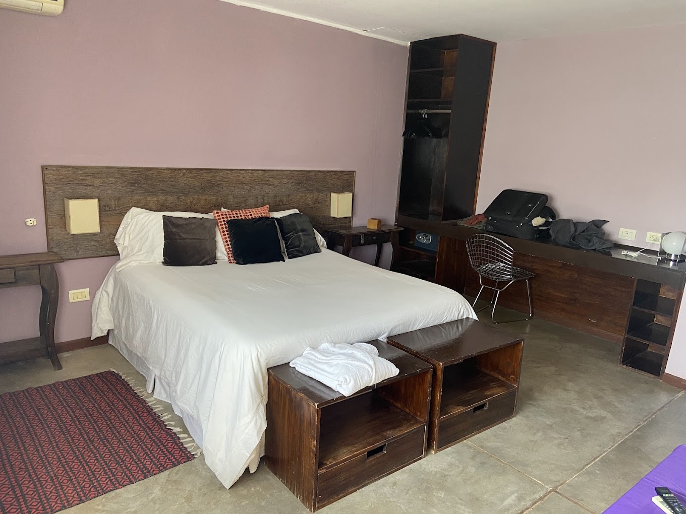 Habitación doble con muebles de madera y paredes lila en el Cezeta Hotel