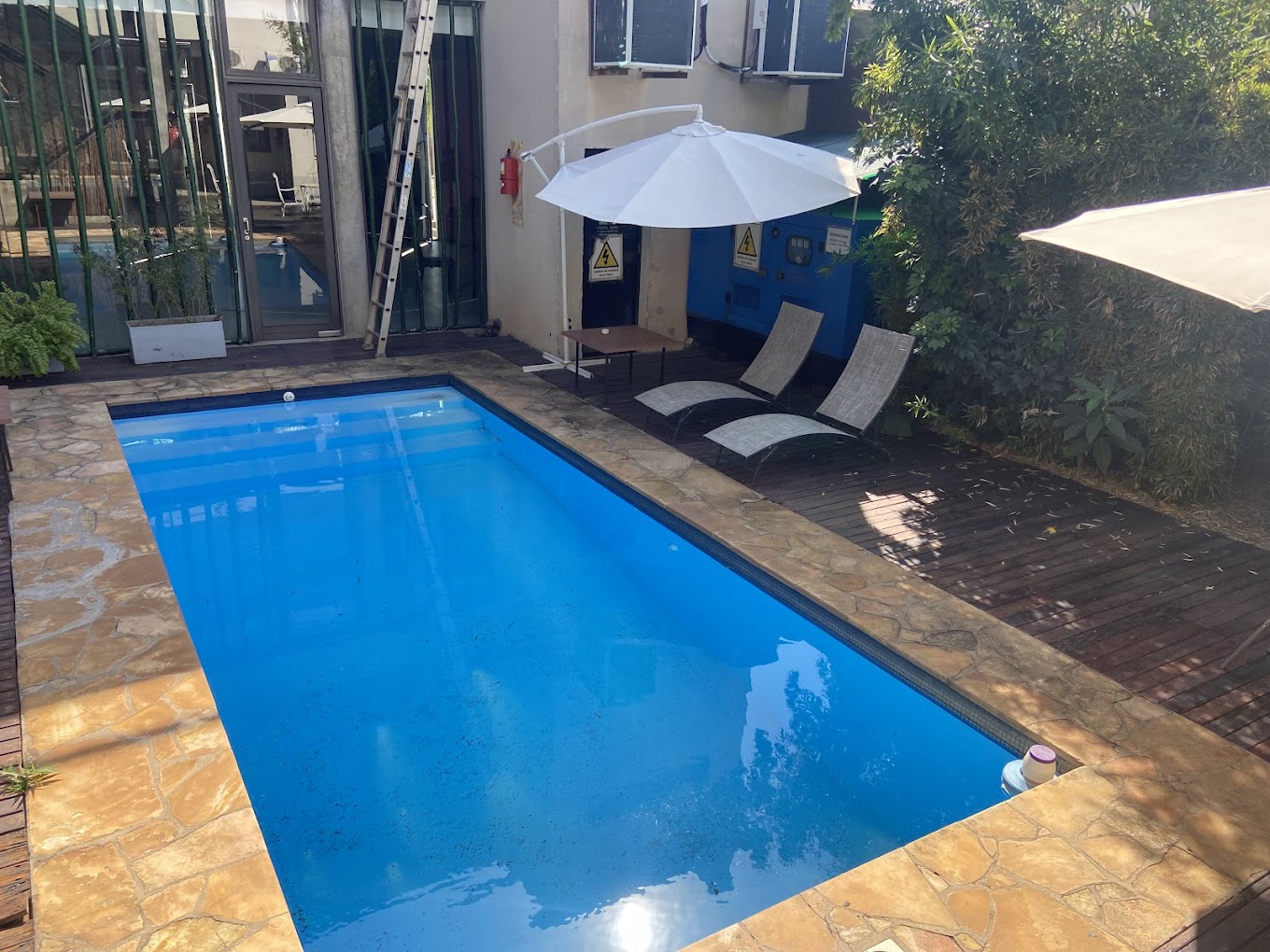 Piscina con reposeras al sol en el patio del Cezeta Hotel