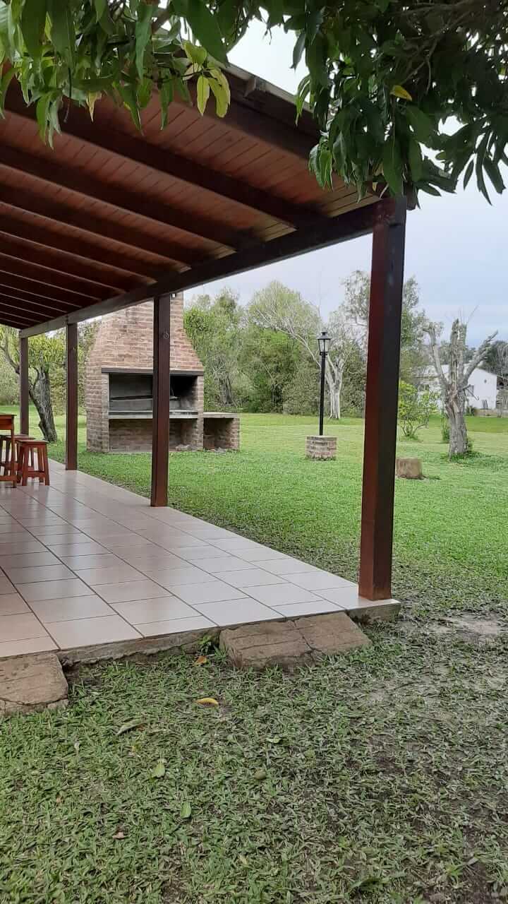 Galería techada con parrilla y jardín verde
