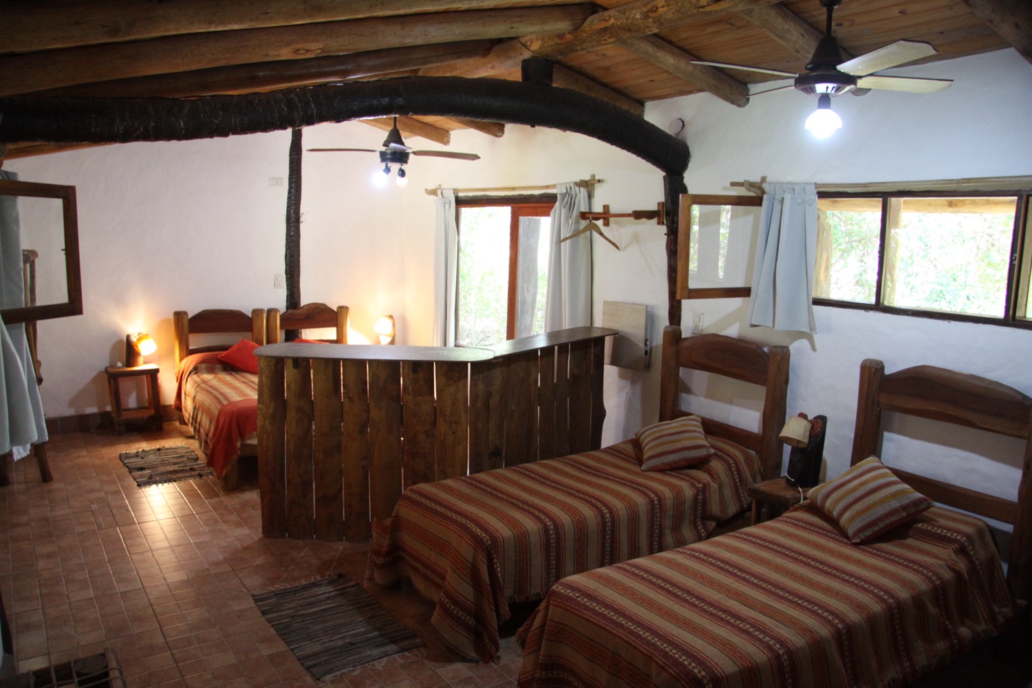 Habitación familiar con múltiples camas y techos de vigas de madera