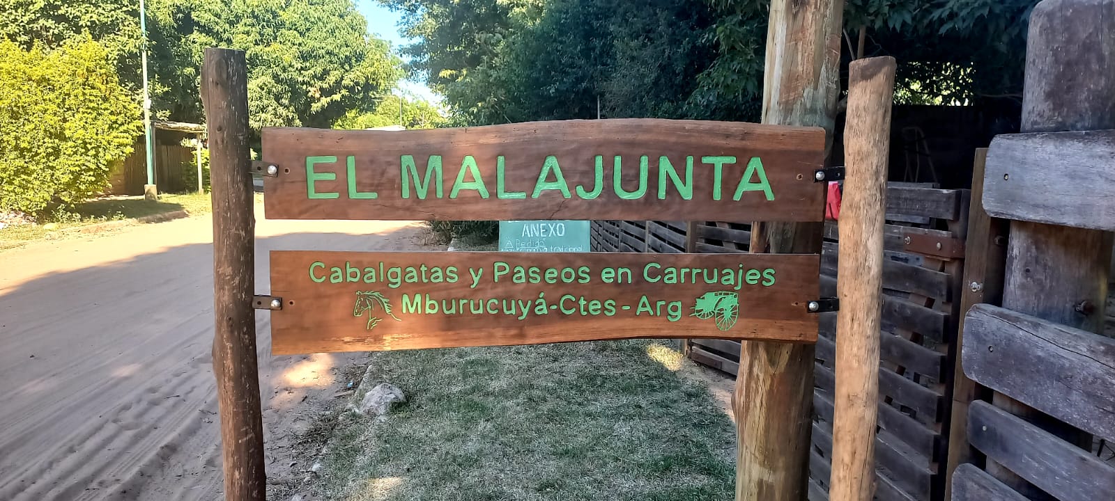 El cartel de entrada, sobre el camino de tierra