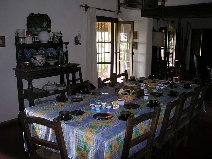 Comedor histórico con mesa larga y vajilla colonial