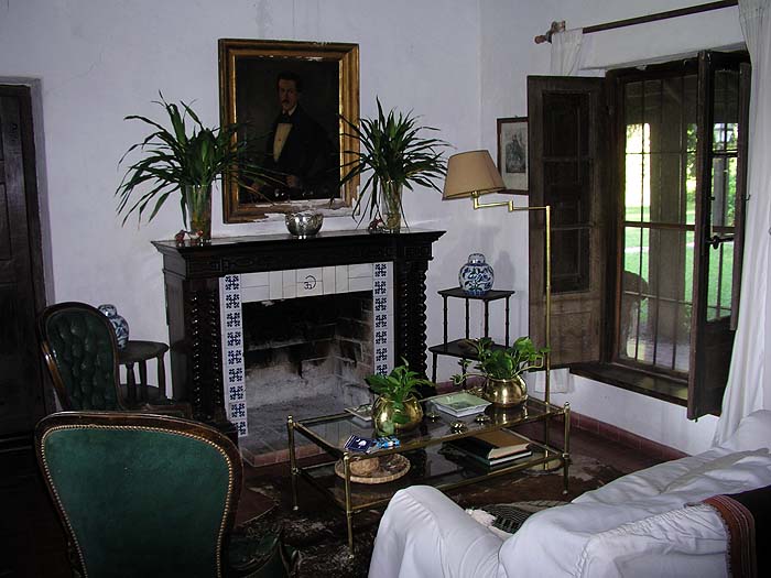 Salón con chimenea y retrato histórico  -  interiores coloniales