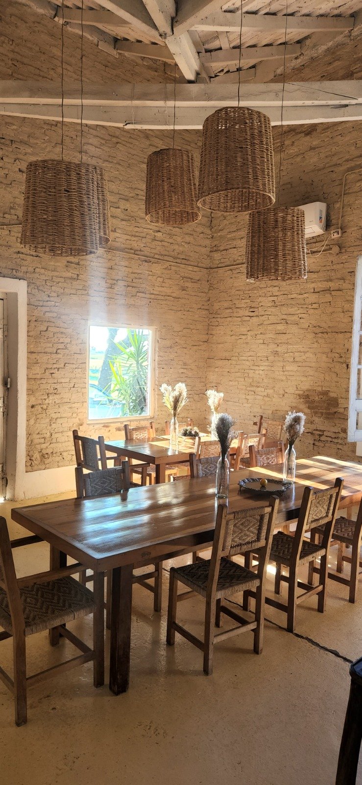 Dining room with wooden tables and wicker lamps