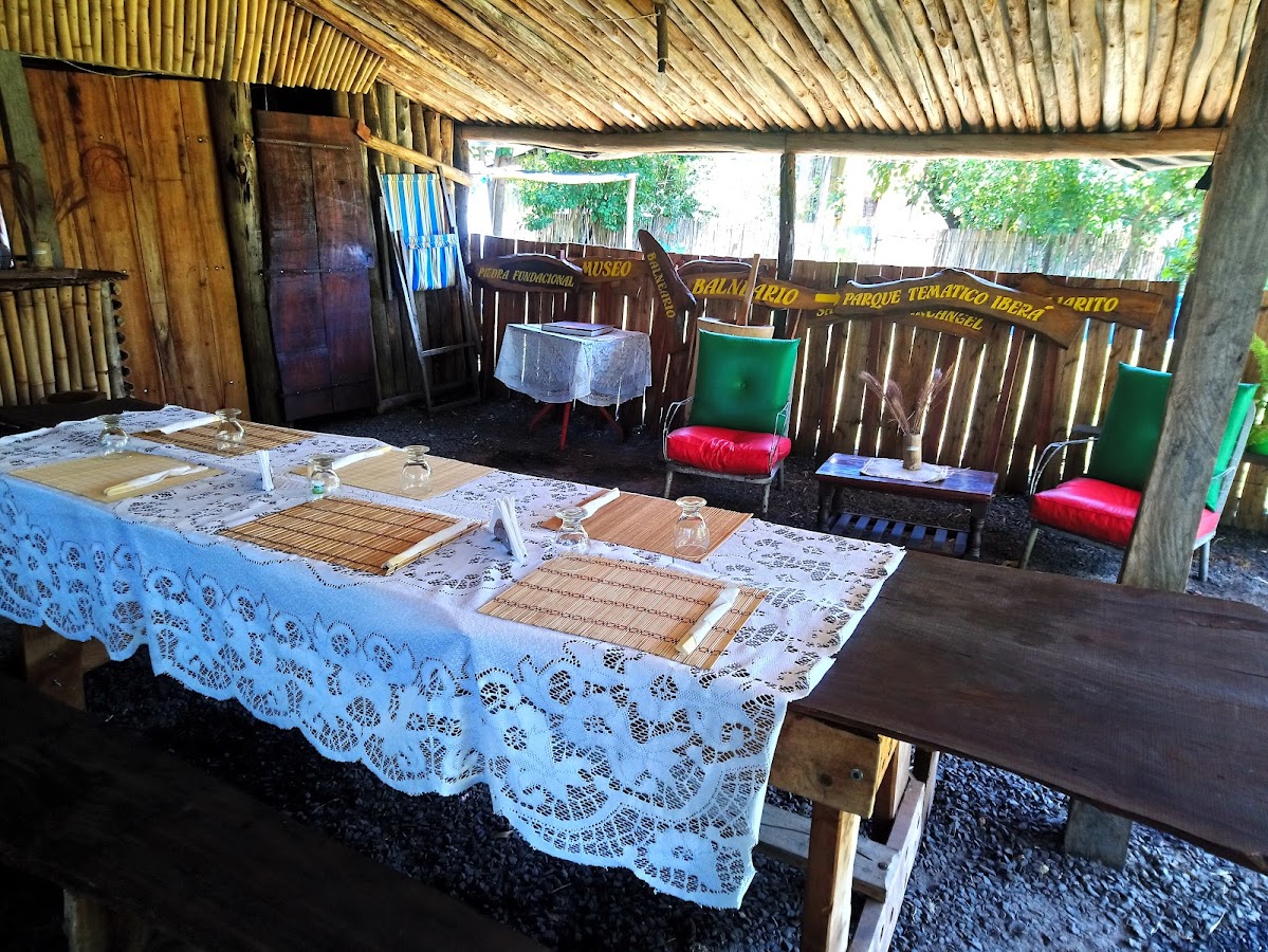 Salón interior con techo de totora y mesas con manteles de encaje