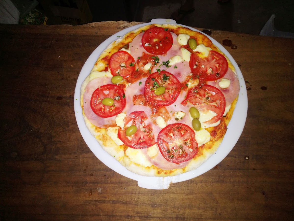 Pizza con tomate fresco, jamón, mozzarella y aceitunas