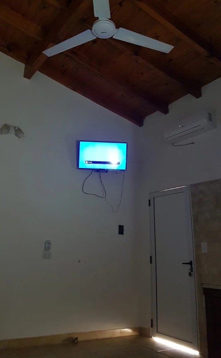 Room with air conditioning, ceiling fan and TV