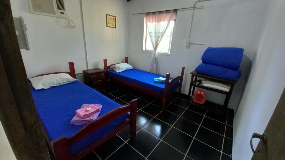 A room with two single beds and air conditioning