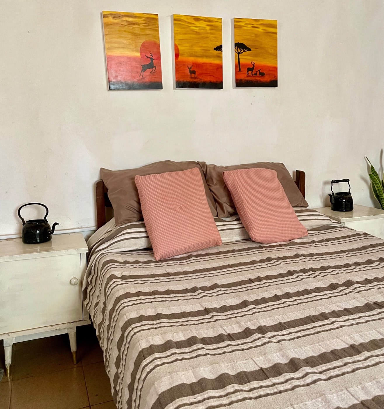Habitación matrimonial, con los cuadros sobre la cama