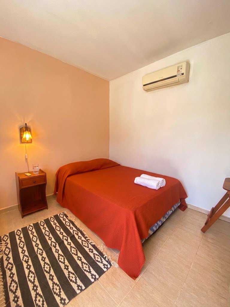 Una habitación con cama matrimonial y aire acondicionado
