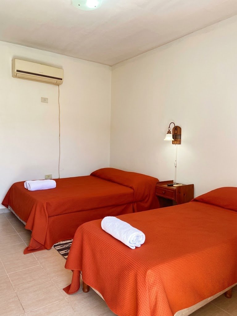 Una habitación con dos camas y aire acondicionado