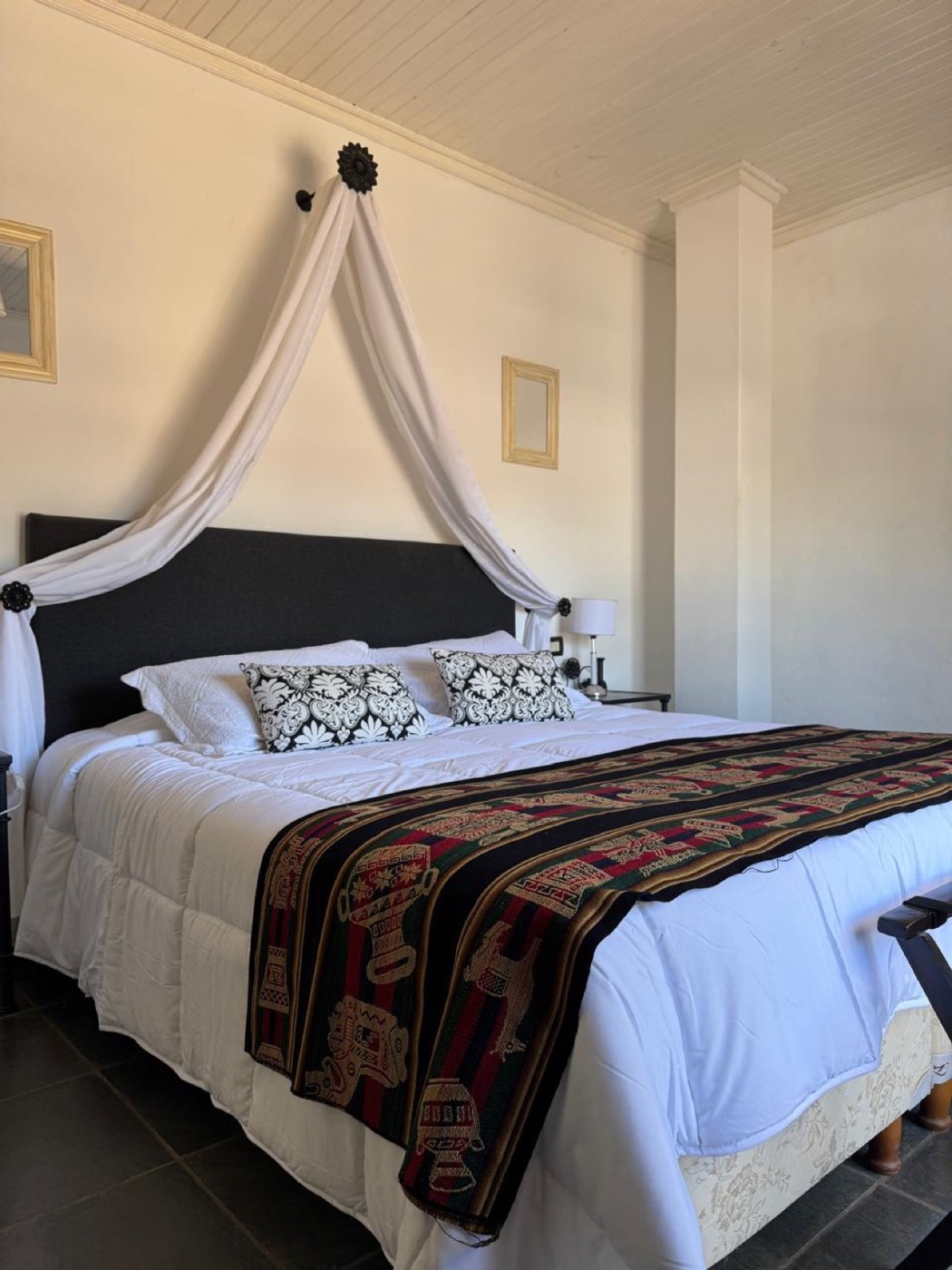 Habitación con cama king y el dosel blanco