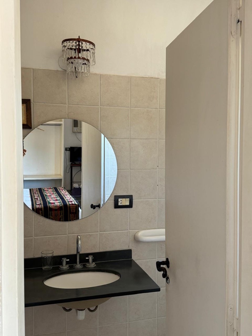 El baño, con el espejo redondo