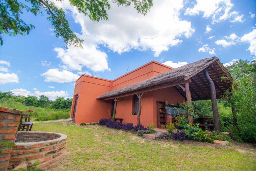 Vista exterior del lodge con techo de paja y jardín