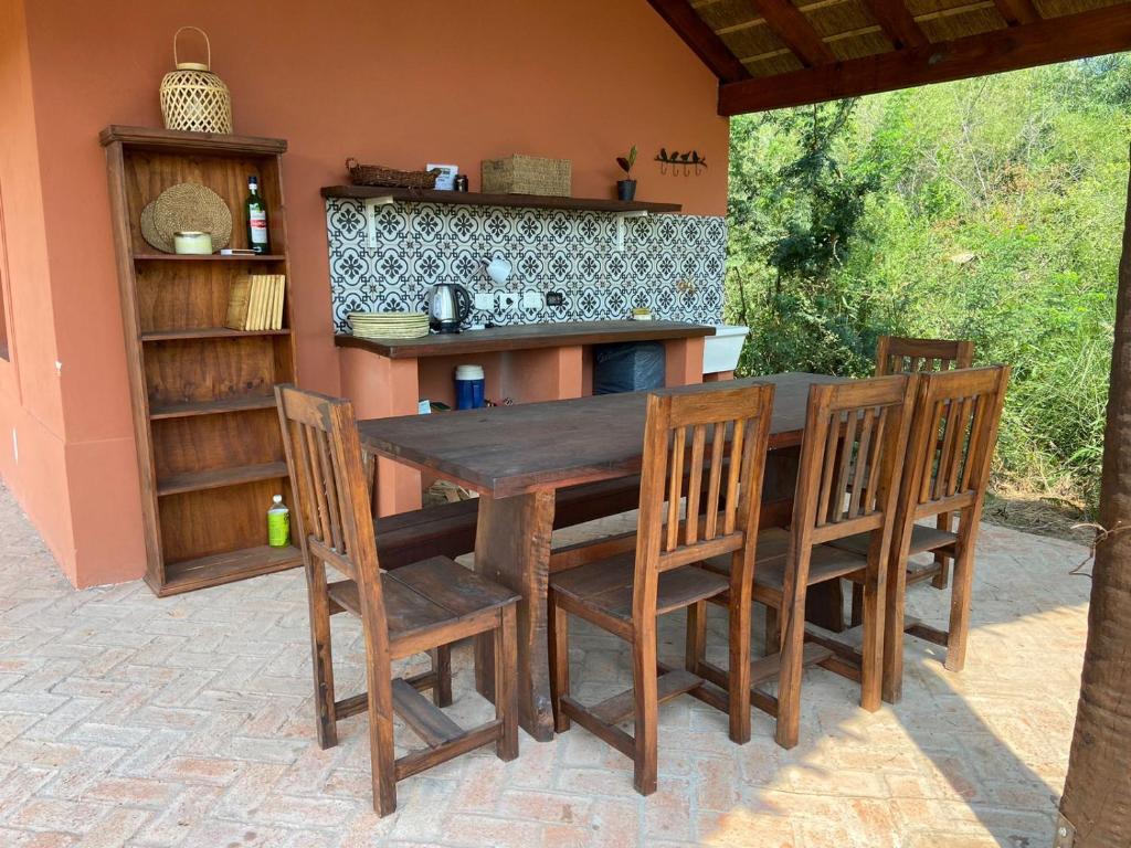 Galería cubierta con mesa de madera y cocina exterior