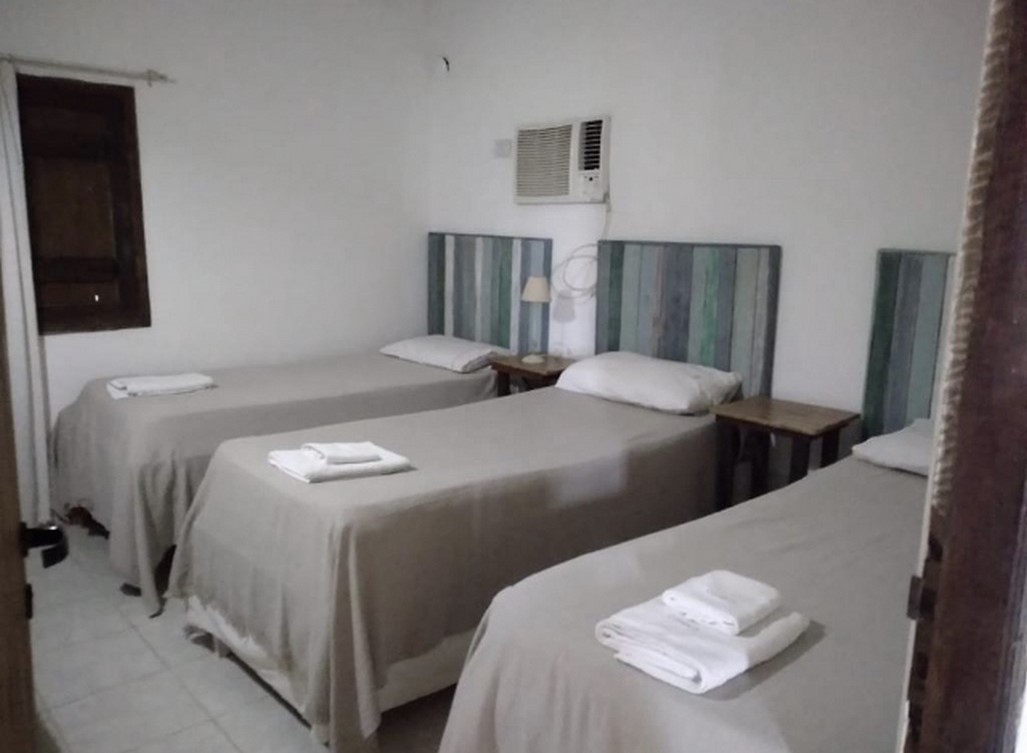 Habitación triple con AC y cabeceras de madera