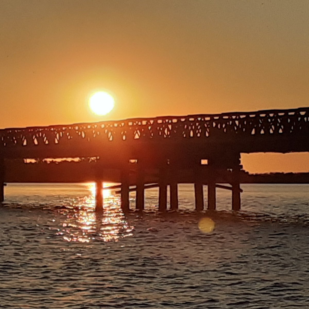 Atardecer naranja sobre el puente histórico de Iberá  -  vista en lancha