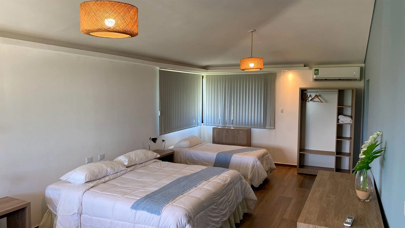 Habitación estándar con tres camas y piso de madera