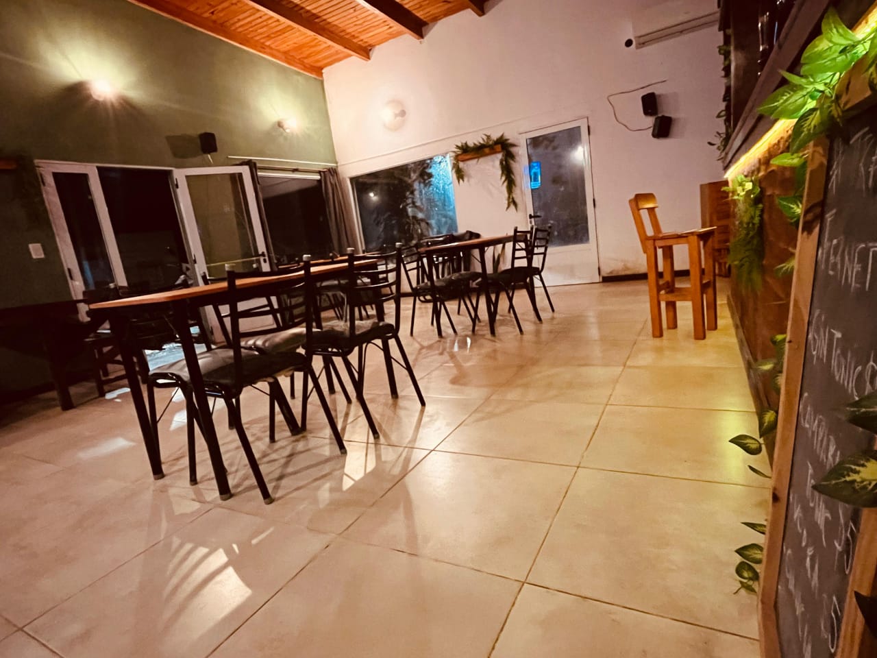 Interior del Kiwi Bar de noche, menu en pizarra y ambiente tranquilo