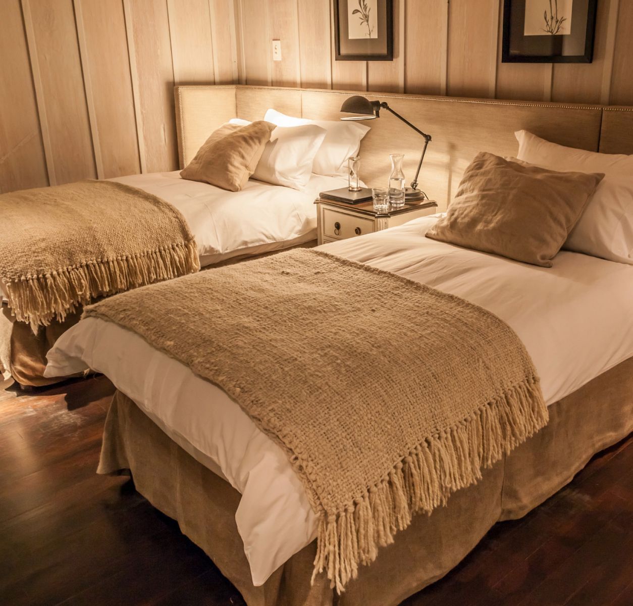 Habitación twin con mantas tejidas a telar y piso de madera