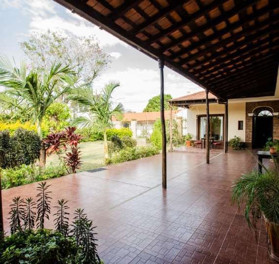Galería con piso de baldosa que mira al jardín