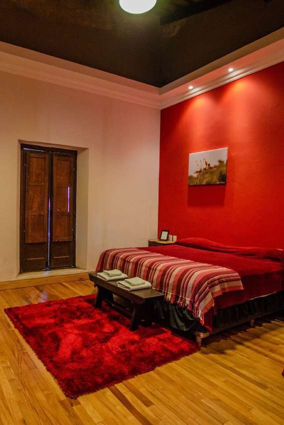 Habitación roja con puerta de madera y alfombra