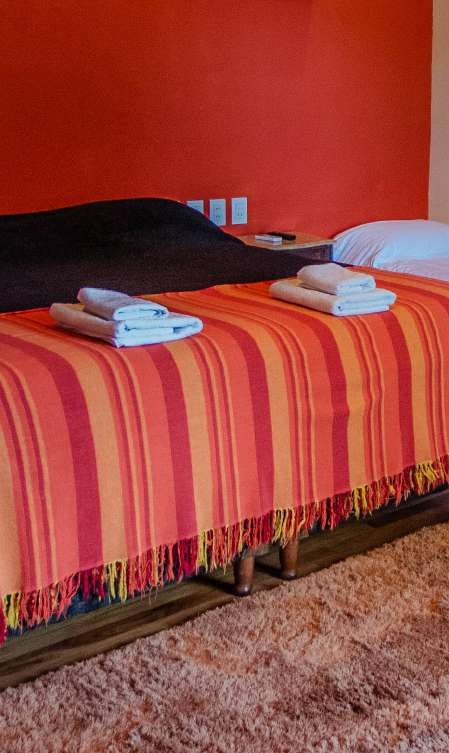 Cama con acolchado a rayas y las toallas listas