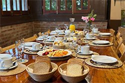 Mesa de desayuno regional con pan casero, frutas y dulces
