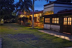 Posada iluminada de noche entre palmeras y jardín correntino