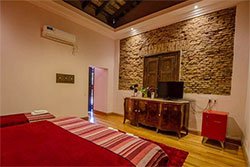 Habitación doble con pared de piedra y cama matrimonial