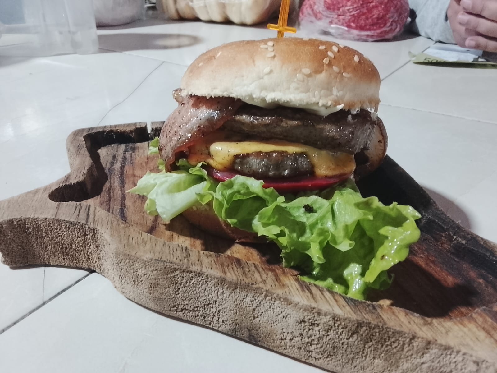 Hamburguesa casera servida en tabla de madera