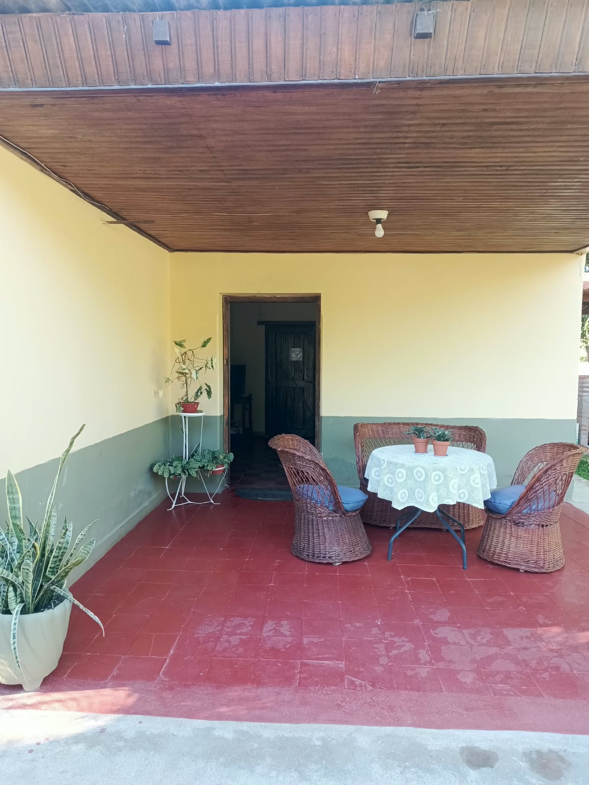 The veranda, with a table and wicker armchairs