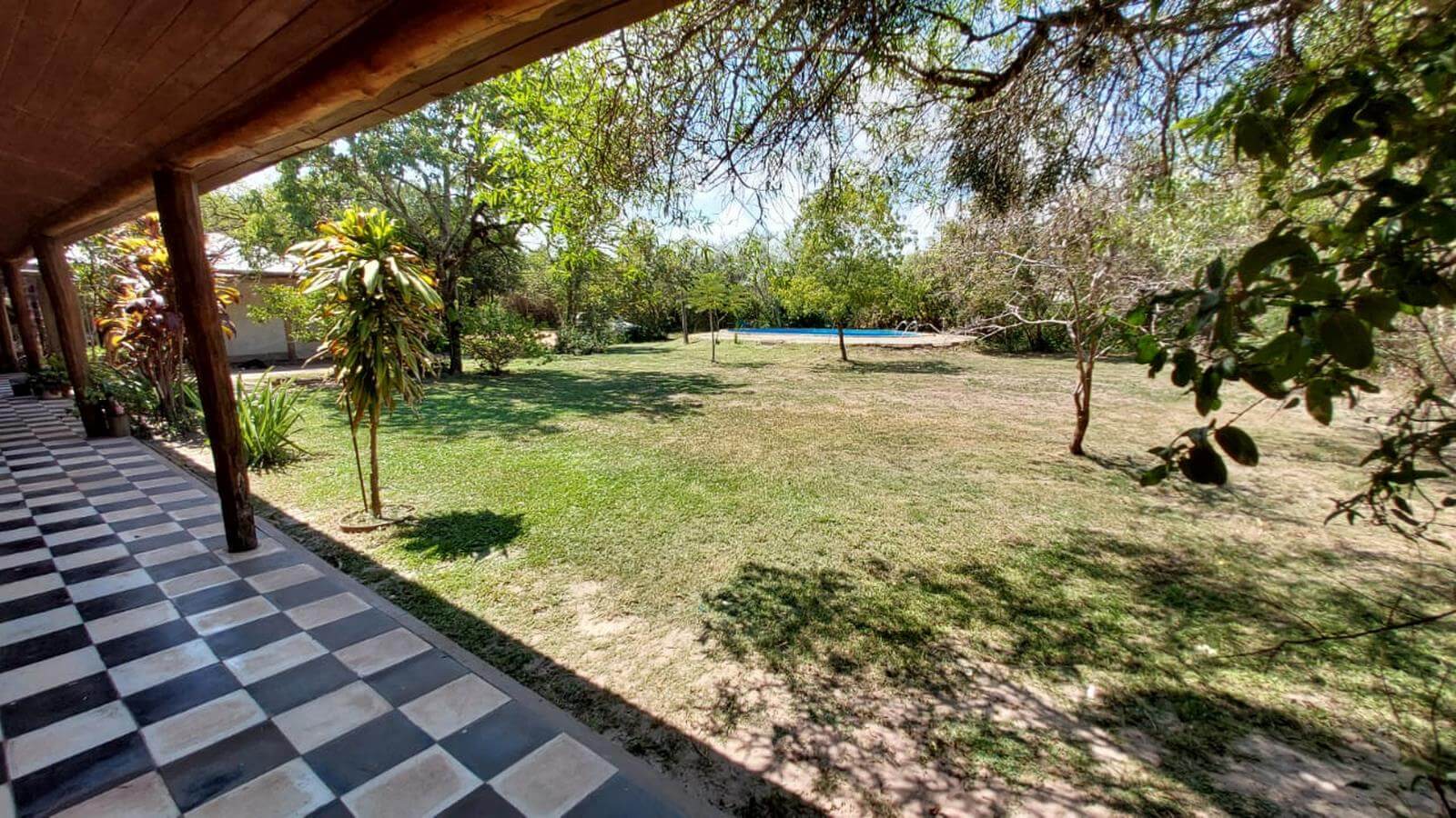 Jardín arbolado con piscina al fondo