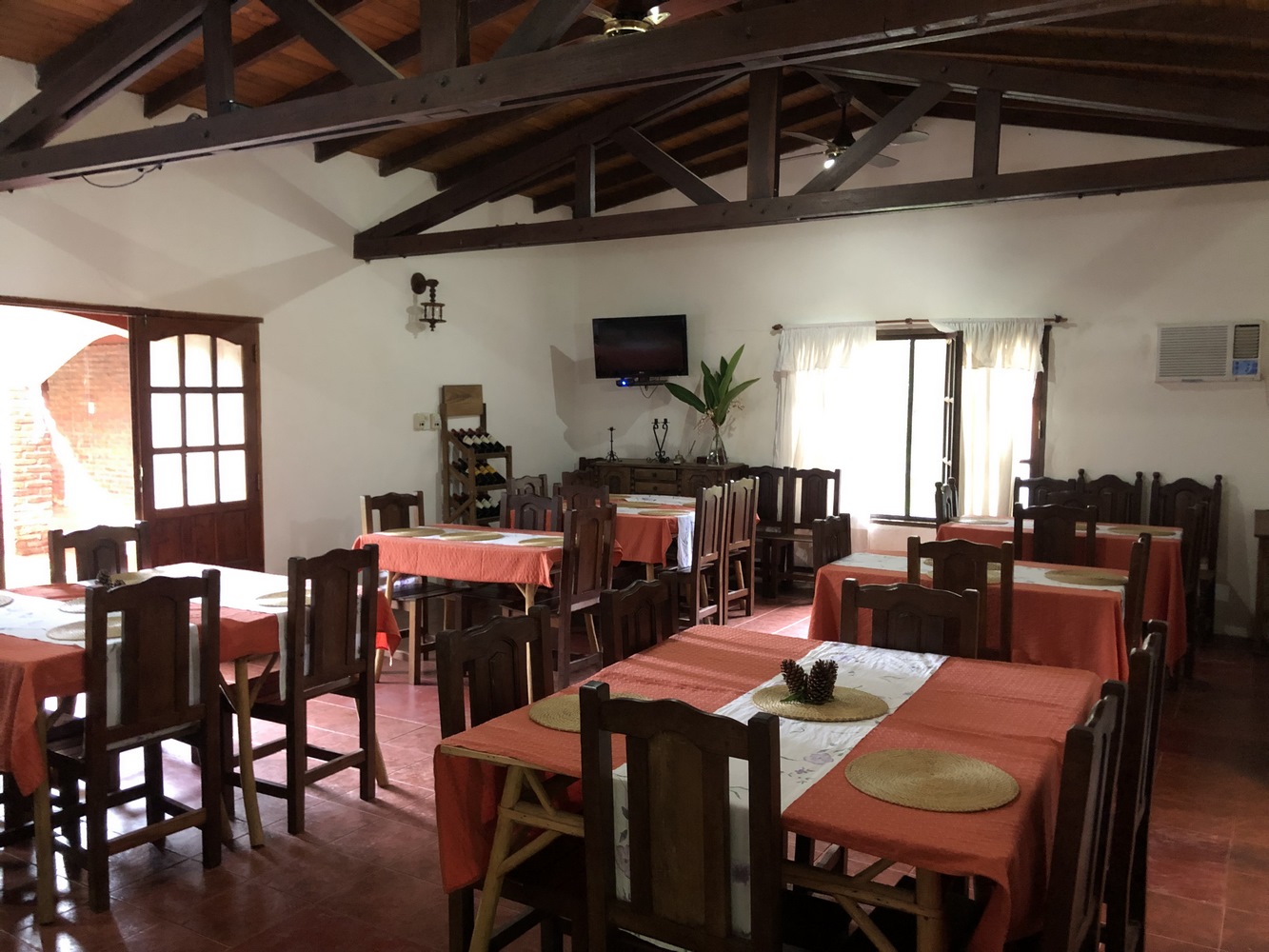 Comedor con mesas vestidas y vigas de madera