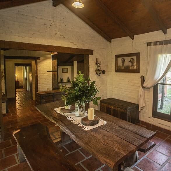 Comedor principal con mesa de madera maciza y vigas vistas