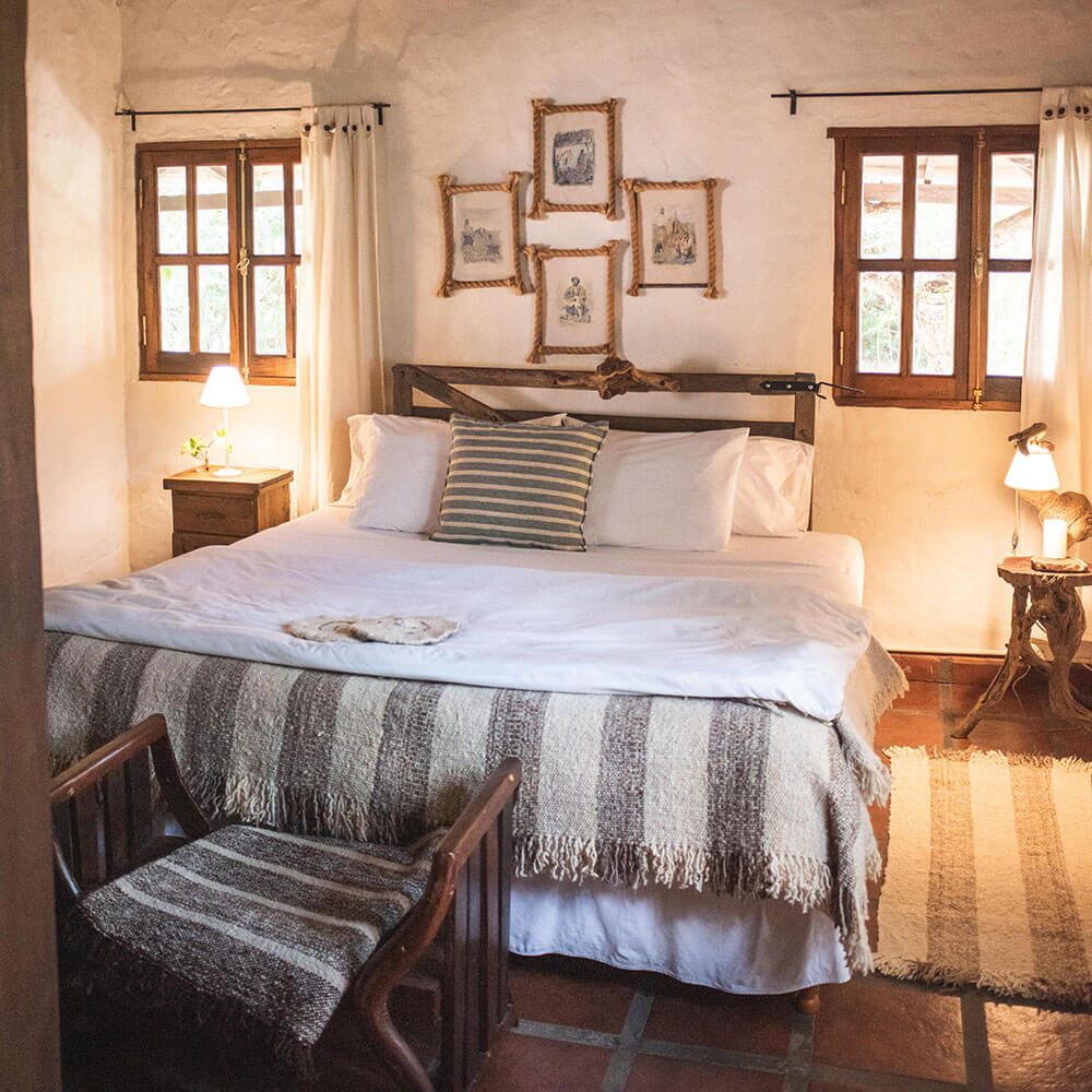 Habitación acogedora con paredes de adobe y cuadros en cuerda