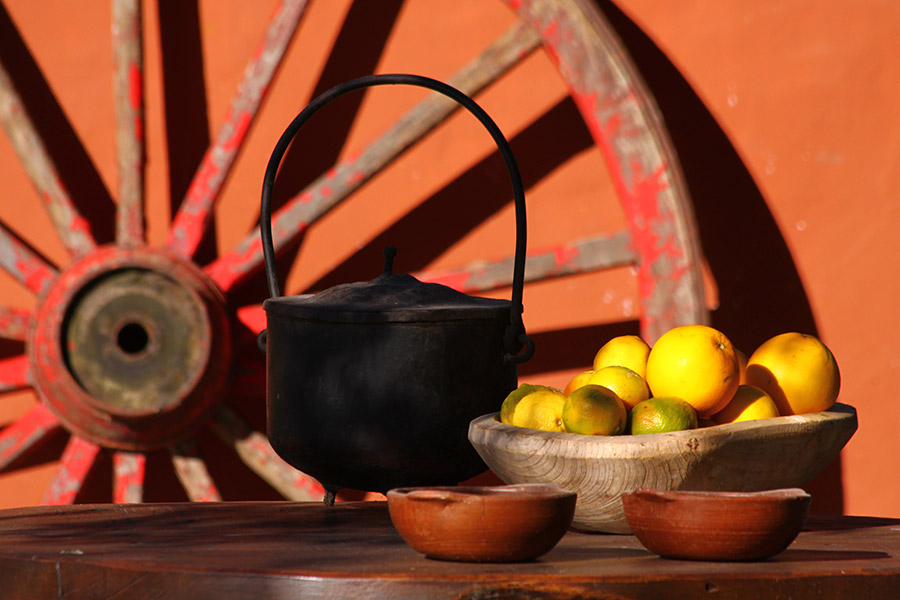 Olla de hierro y frutas sobre rueda de carreta  -  decoración rural correntina